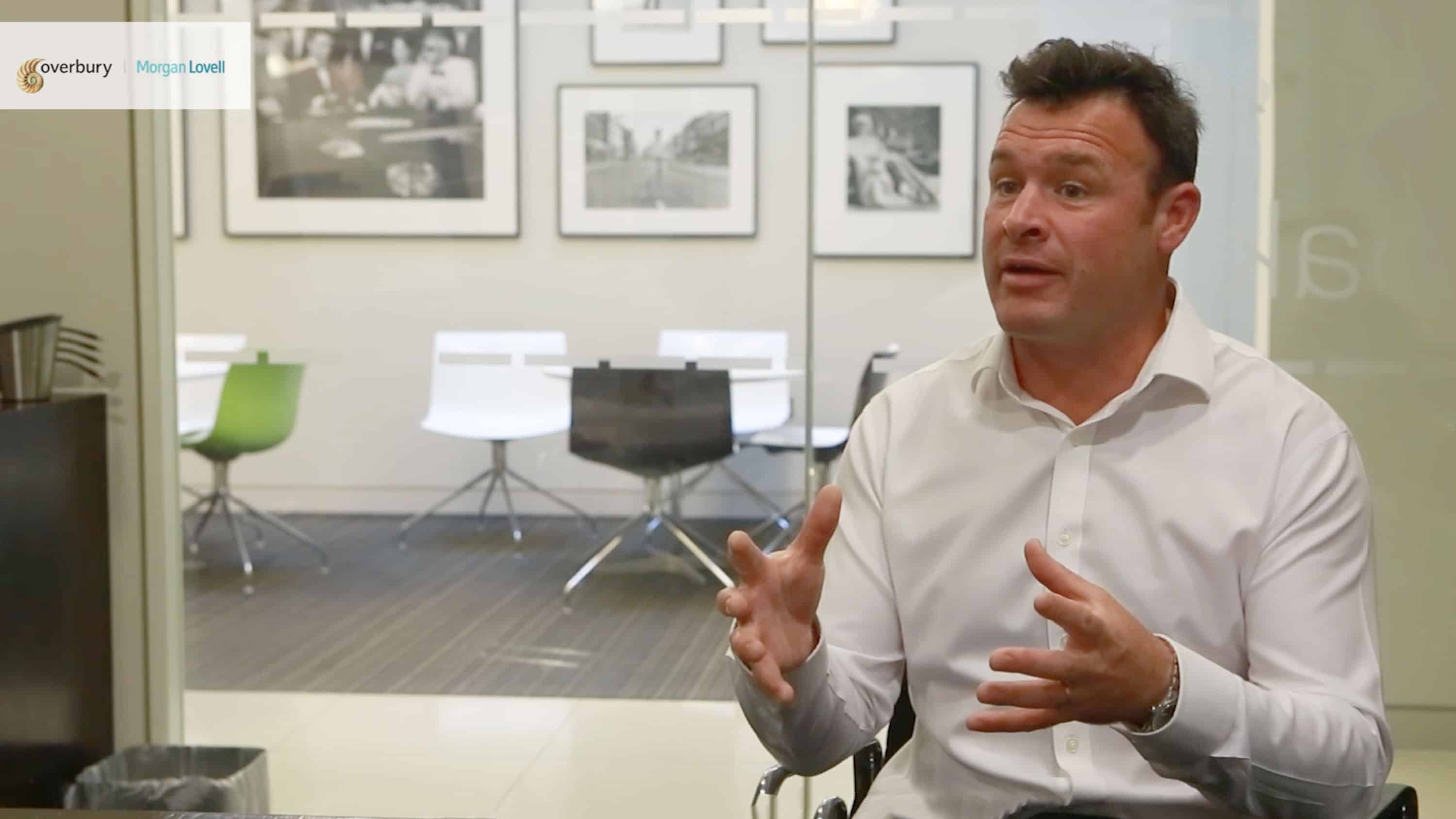 Man sitting in office talking to camera